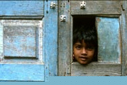 Boy looking through hole in door