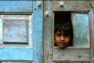 Boy looking through hole in door